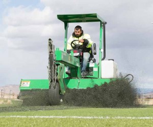 John Byrne/Tribune A FieldTurf employee steers a machine to scrape the artificial turf on one of the multi-purpose fields at Golden Eagle Regional Park on Monday. 
