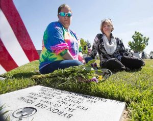 John Byrne/Tribune Sparks residents Tirzah Sneed (left) and Charlene Young (right) laid flowers at the grave site of family members Byron Young and his wife Joyce on Monday at the Northern Nevada Veterans Memorial Cemetery in Fernley. Byron, a Navy Veteran of World War II, was a 1940 era Sparks High School graduate. Thousands gathered for the Memorial Day ceremony where Nevada Governor Brian Sandoval delivered one of the keynote speeches. More photos on page 6.