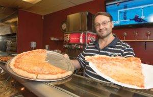 John Byrne/Tribune - Paul Erikson, owner of True New York Pizza Co. in Sparks, displays one of the many pizza’s offered at his restaurant on Vista Boulevard.