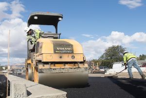 John Byrne/Tribune -  Road crews pour and level asphalt Friday morning at the corner of Pyramid and McCarran Boulevard in Sparks.